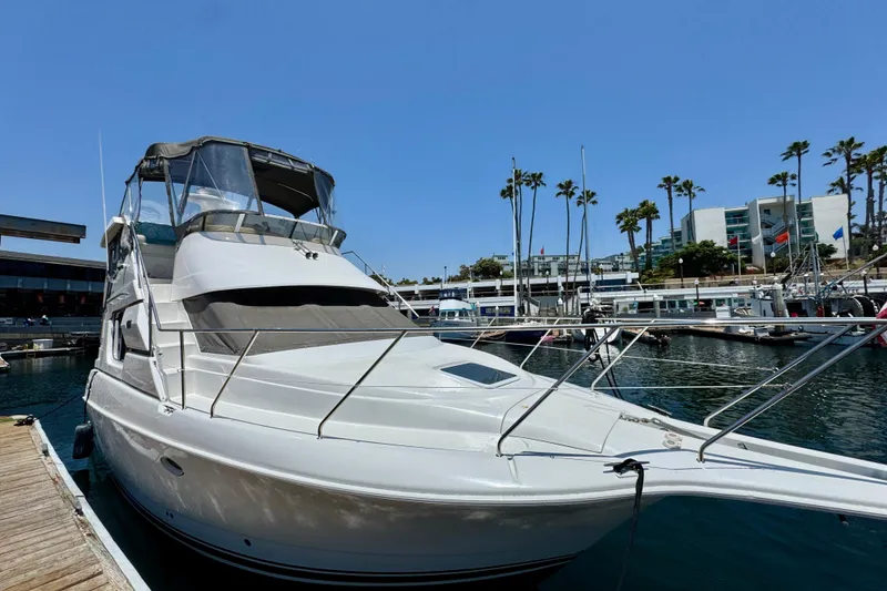 Slide: The Image of 1999 Silverton 322 Motor Yacht docked at a marina under clear blue skies. - 38