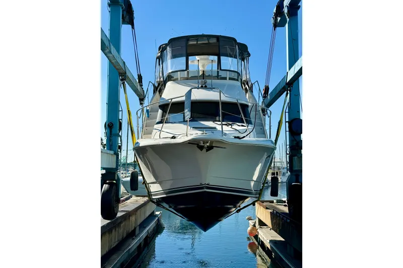 Slide: The Image of 1999 Silverton 322 Motor Yacht suspended in a boat lift at a marina. - 40