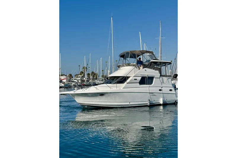 Slide: The Image of 1999 Silverton 322 Motor Yacht docked in a marina under clear blue skies. - 1