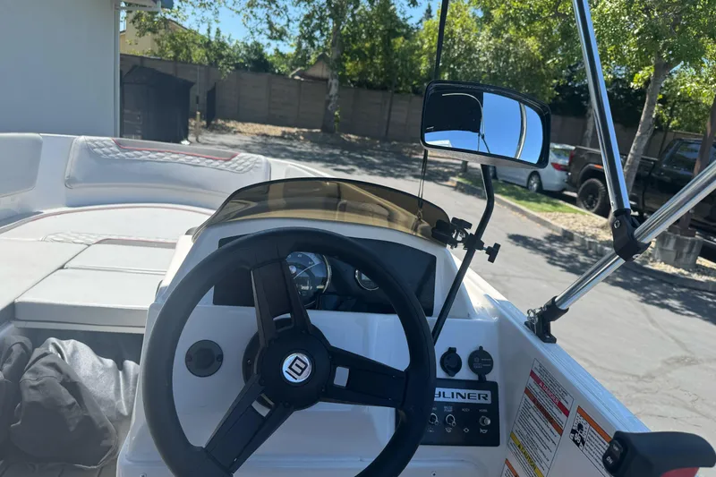 Slide: The Image of 2023 Bayliner Element M15 boat dashboard with steering wheel and controls. - 14