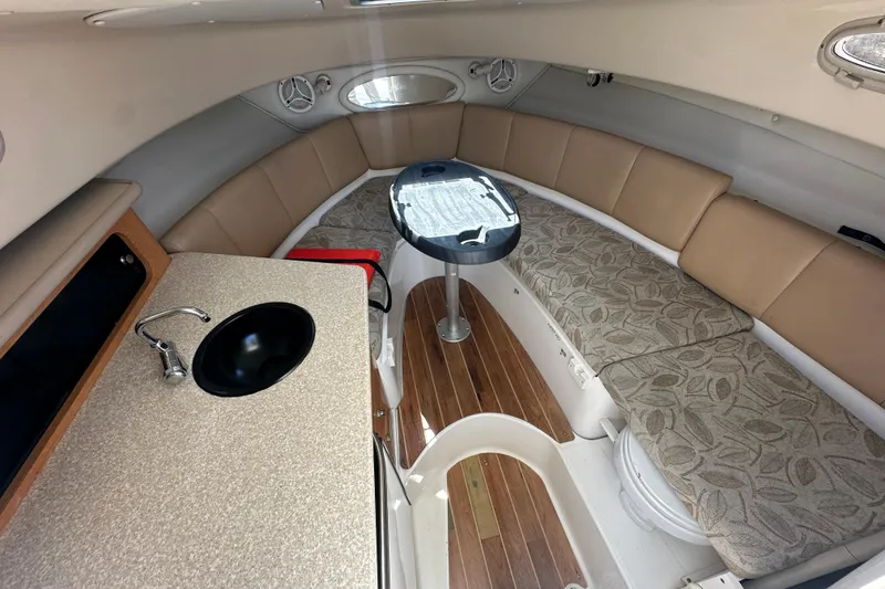 Slide: The Image of Interior of 2006 Robalo R245 Walkaround boat with seating, table, and sink. - 13