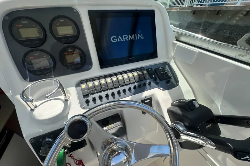 Slide: The Image of 2006 Robalo R245 Walkaround boat dashboard with Garmin display and Yamaha controls. - 18