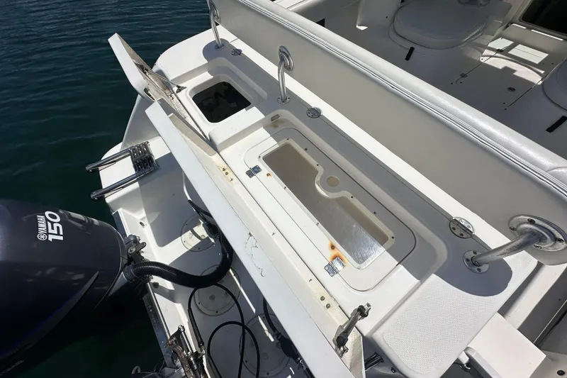 Slide: The Image of 2006 Robalo R245 Walkaround boat with Yamaha 150 engine, featuring open storage compartments. - 20