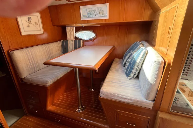 Slide: The Image of Cozy dining area in 1989 Ocean Alexander 440 Sundeck CPMY with wood finish and striped cushions. - 13