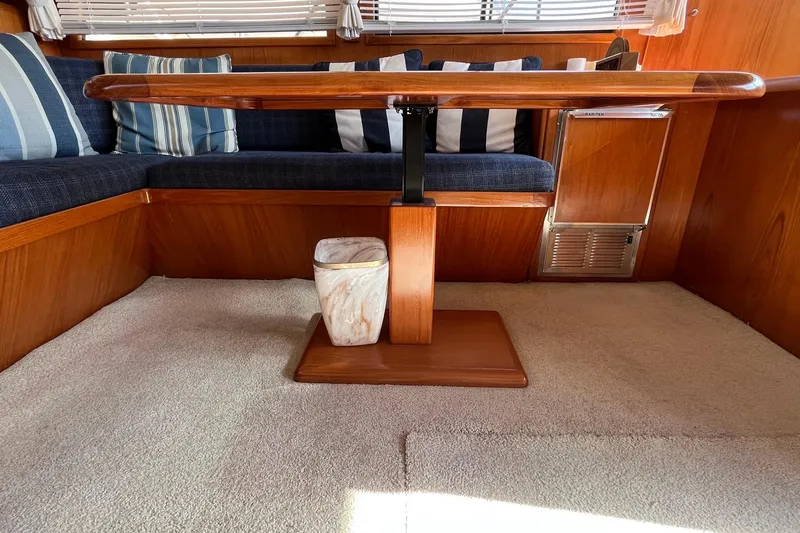 Slide: The Image of Interior of 1989 Ocean Alexander 440 Sundeck CPMY with wooden table and striped cushions. - 24