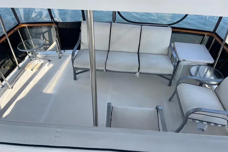 Slide: The Image of 1989 Ocean Alexander 440 Sundeck CPMY interior with seating and tables on deck. - 27
