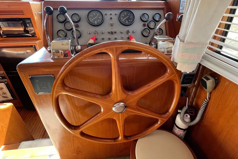 Slide: The Image of 1989 Ocean Alexander 440 Sundeck CPMY helm with wooden wheel and control panel. - 6
