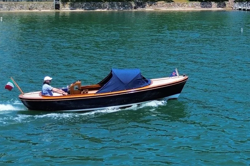 Slide: The Image of 2003 Castine Harbor Launch cruising on clear blue water with a person onboard. - 27