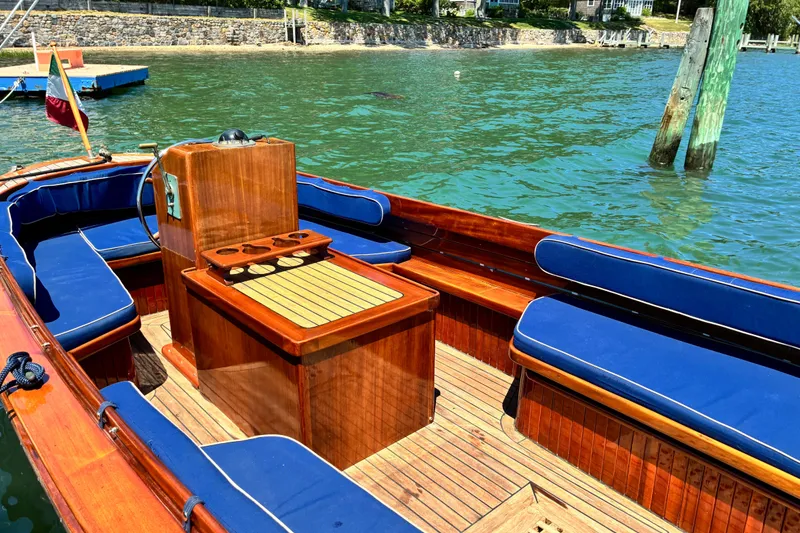Slide: The Image of Elegant 2003 Castine Harbor Launch with blue seating, docked in clear waters. - 14