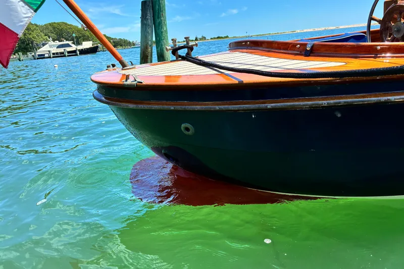 Slide: The Image of 2003 Castine Harbor Launch boat on clear blue water, showcasing elegant wooden design. - 16