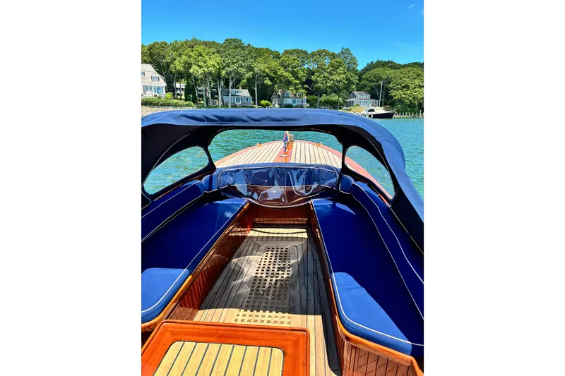Slide: The Image of Interior view of a 2003 Castine Harbor Launch boat with blue seating and wooden deck. - 5