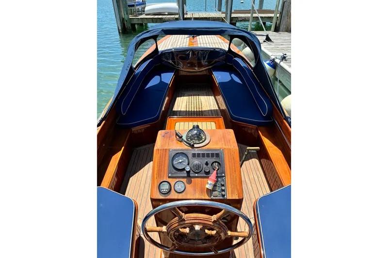 Slide: The Image of Interior view of a 2003 Castine Harbor Launch boat with wooden dashboard and blue seating. - 26