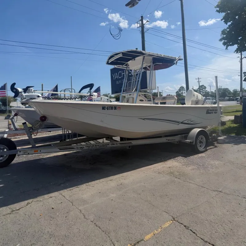 The Image of 2019 Carolina Skiff 218 DLV boat on trailer, displayed outdoors at dealership. - 0