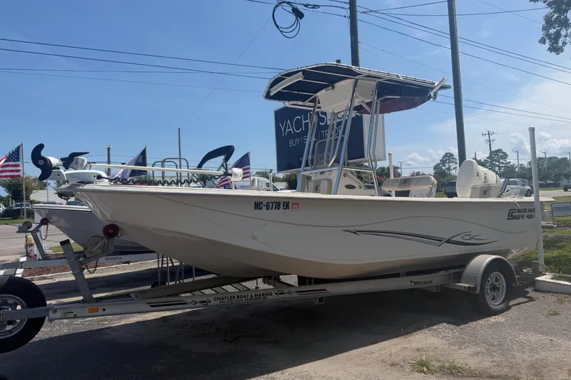 The Image of 2019 Carolina Skiff 218 DLV boat on trailer, displayed outdoors at dealership. - 2
