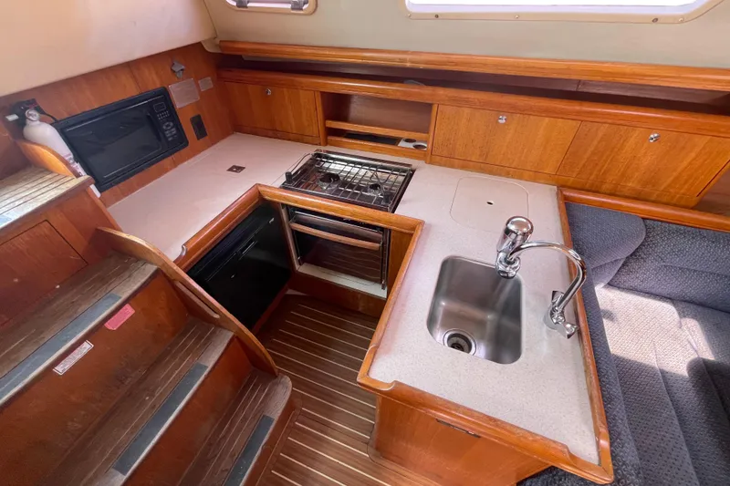 Slide: The Image of 2004 Hunter 33-2 yacht interior kitchen with sink, stove, and microwave. - 14