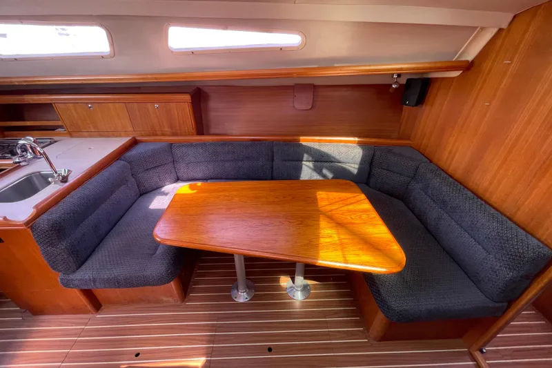 Slide: The Image of Cozy interior of 2004 Hunter 33-2 sailboat with wooden table and cushioned seating. - 19