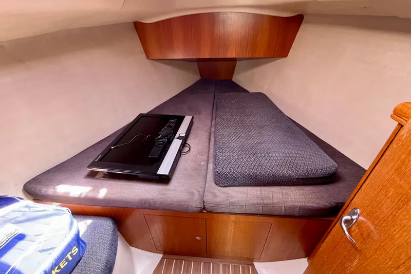 Slide: The Image of 2004 Hunter 33-2 sailboat interior cabin with cozy bedding and wooden accents. - 21