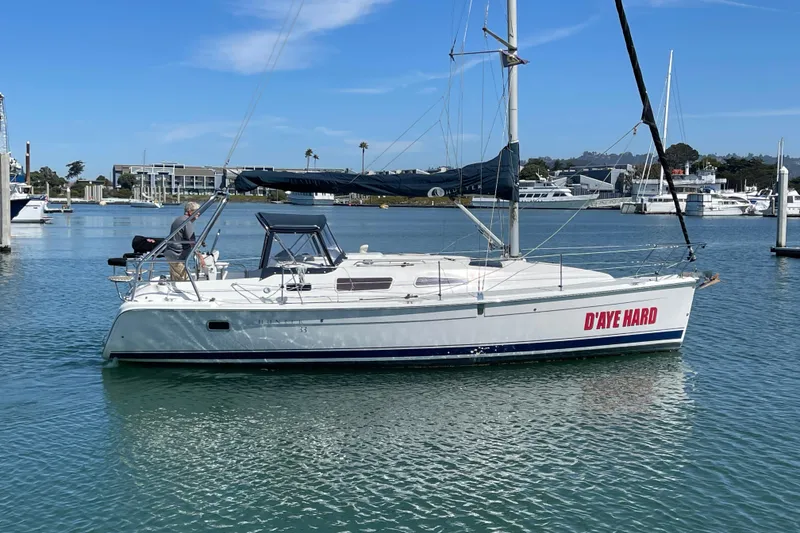 Slide: The Image of 2004 Hunter 33-2 sailboat named "D'AYE HARD" docked in a marina. - 30