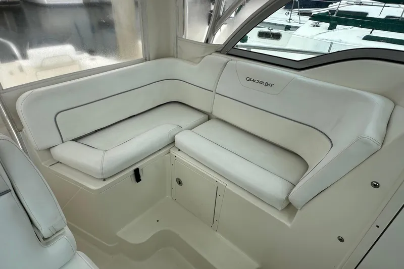 Slide: The Image of 2013 Glacier Bay 2680 Coastal Runner interior with white cushioned seating. - 12
