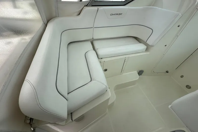 Slide: The Image of Interior seating of 2013 Glacier Bay 2680 Coastal Runner boat, featuring white cushioned seats. - 13