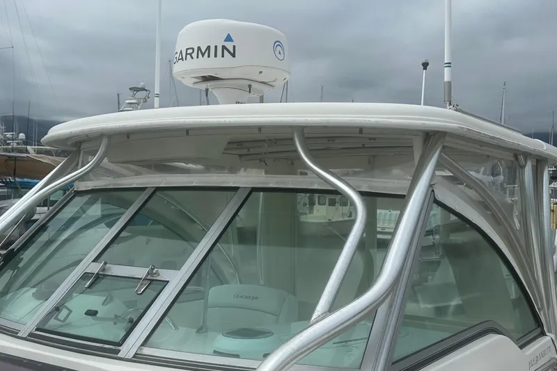 Slide: The Image of 2013 Glacier Bay 2680 Coastal Runner boat with Garmin radar, docked under cloudy skies. - 6