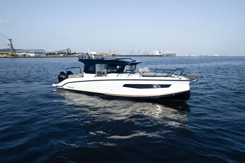 The Image of A modern motorboat cruises on calm water, surrounded by a harbor with industrial buildings. - 0