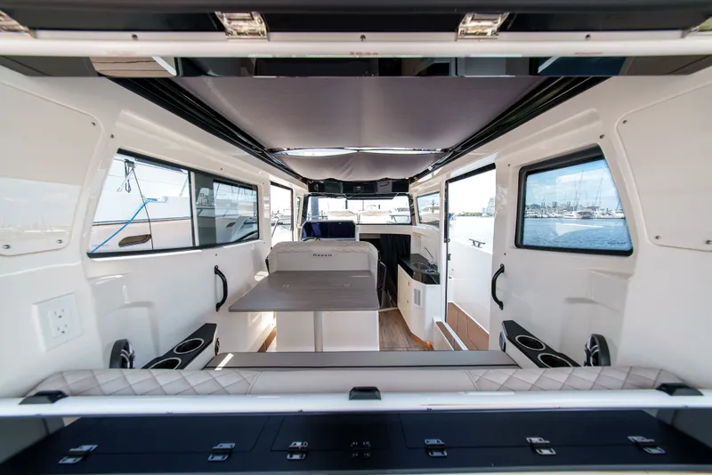 Slide: The Image of Interior view of a modern boat with a table, seating, and windows overlooking the harbor. - 21