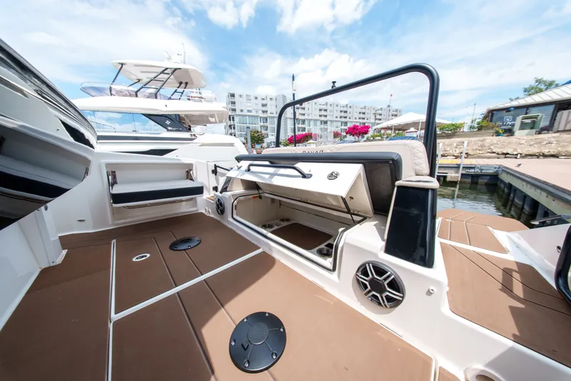 Slide: The Image of A modern boat with an open storage hatch and speaker, docked at a marina. - 9