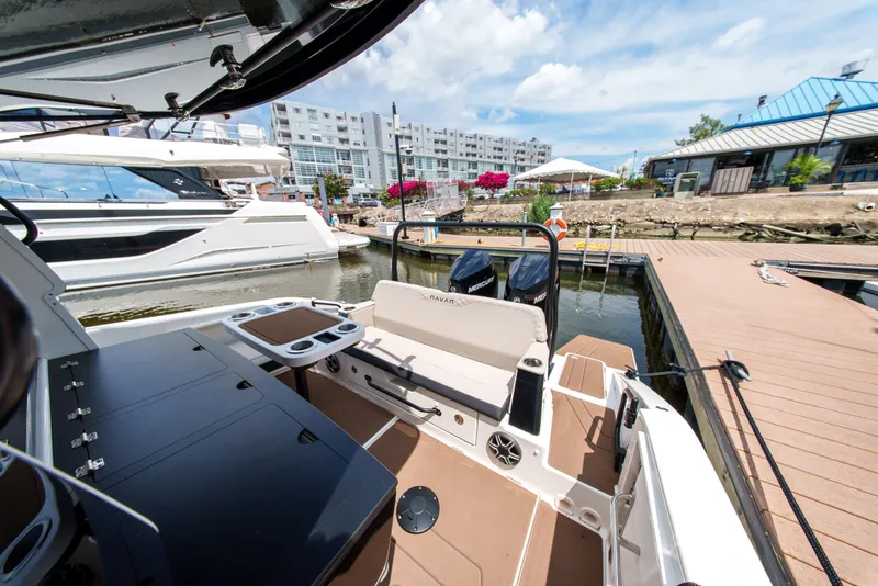 Slide: The Image of A modern boat docked in a marina, surrounded by other boats and buildings. - 10
