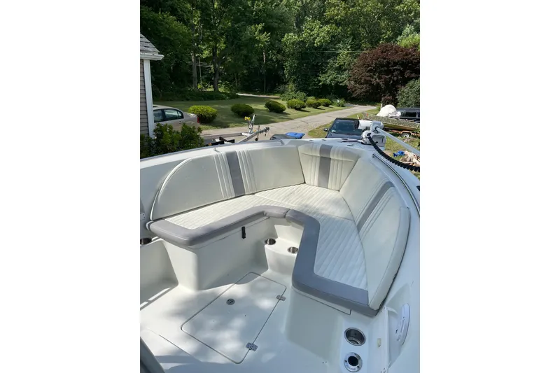 Slide: The Image of 2006 Sailfish 2660 CC boat with cushioned seating, parked in a driveway. - 11