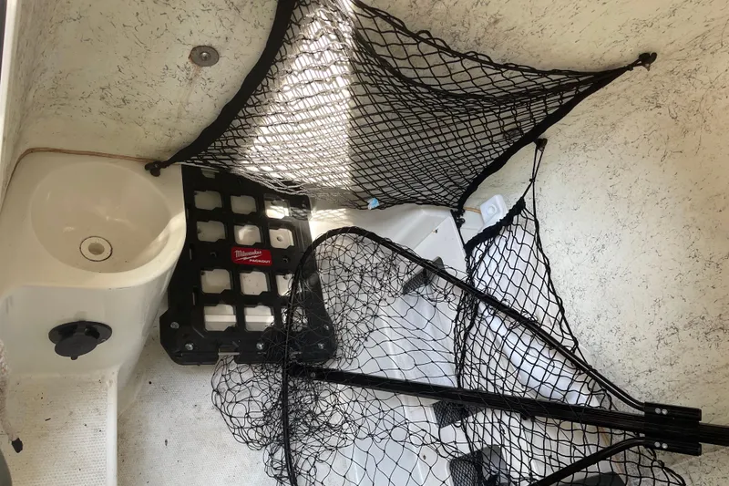 Slide: The Image of Interior of a 2006 Sailfish 2660 CC boat with fishing nets and storage. - 16