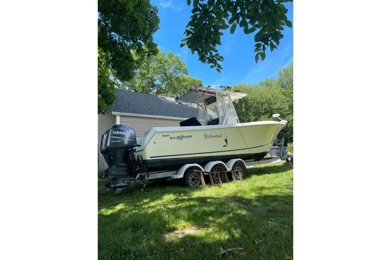 Slide: The Image of 2006 Sailfish 2660 CC boat on trailer, parked in a grassy yard with trees. - 3