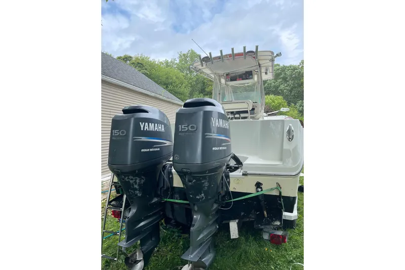 Slide: The Image of 2006 Sailfish 2660 CC boat with dual Yamaha 150 four-stroke engines, parked outdoors. - 4