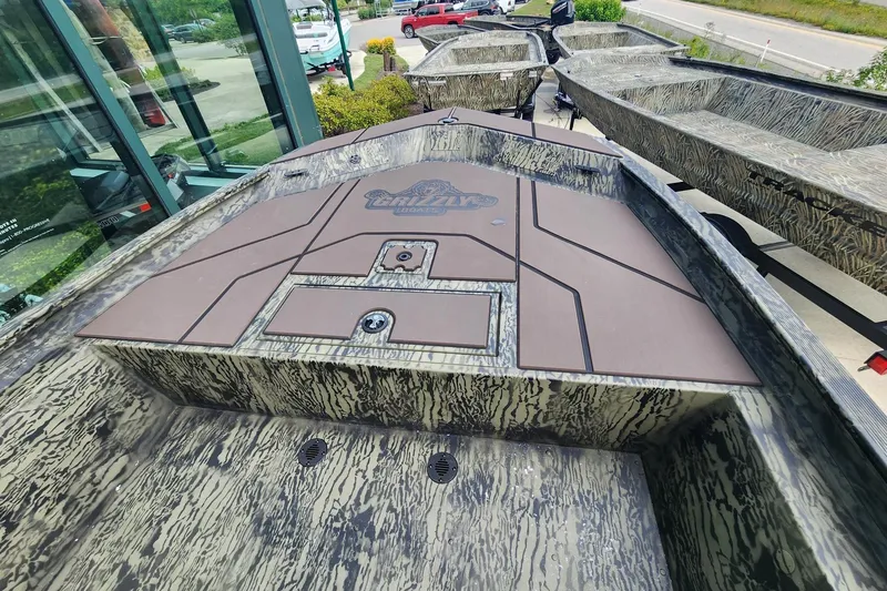 Slide: The Image of 2026 Tracker Grizzly 1860 CC boat with camouflage design, displayed outdoors. - 5