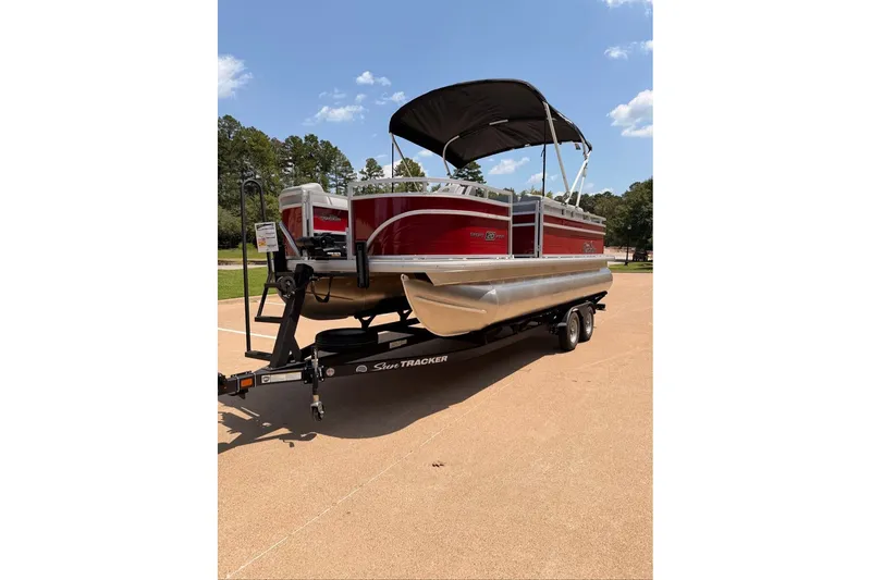 The Image of 2026 Sun Tracker SportFish 20 DLX pontoon boat on trailer, parked outdoors. - 0