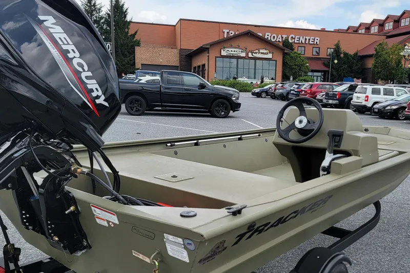 Slide: The Image of 2026 Tracker Grizzly 1648 SC boat with Mercury engine at dealership parking lot. - 2