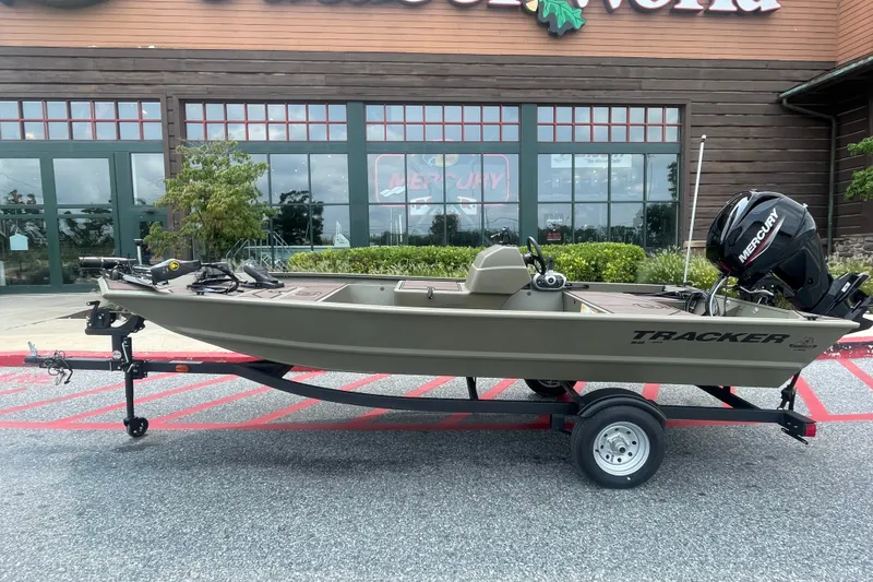The Image of 2026 Tracker Grizzly 1648 SC boat on trailer, parked outside a store. - 0