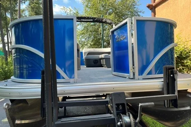 Slide: The Image of 2026 Sun Tracker Party Barge 18 DLX pontoon boat with blue panels and open gate. - 2