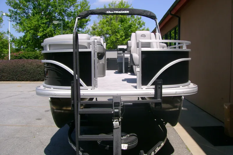 Slide: The Image of 2026 Sun Tracker SportFish 20 DLX pontoon boat on trailer, parked outdoors. - 3