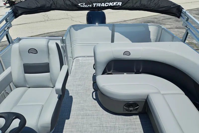 Slide: The Image of 2026 Sun Tracker Party Barge 18 DLX interior with gray seating and steering wheel. - 5