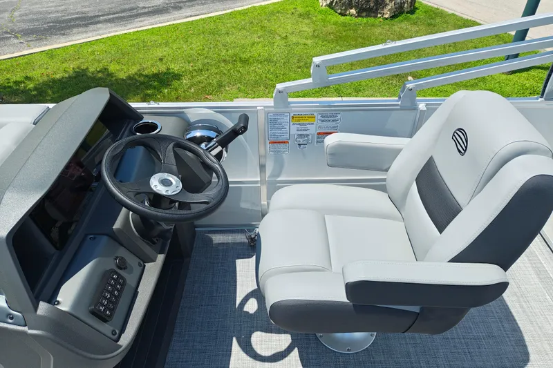 Slide: The Image of 2026 Sun Tracker Party Barge 18 DLX helm with steering wheel and captain's chair. - 12