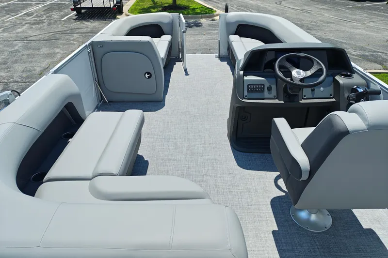 Slide: The Image of 2026 Sun Tracker Party Barge 18 DLX interior with gray seating and steering console. - 8
