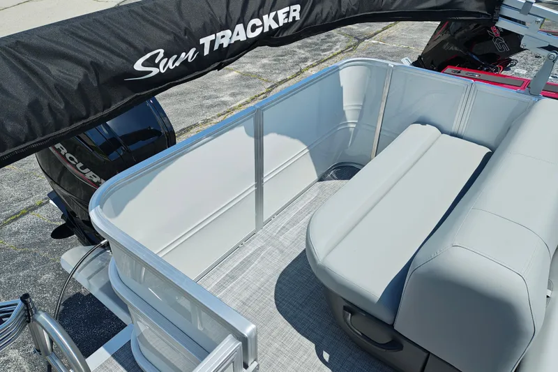 Slide: The Image of 2026 Sun Tracker Party Barge 18 DLX interior with seating and motor view. - 6