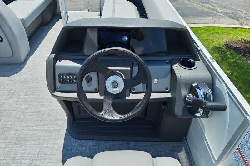 Slide: The Image of 2026 Sun Tracker Party Barge 18 DLX steering console with modern controls and cup holder. - 13