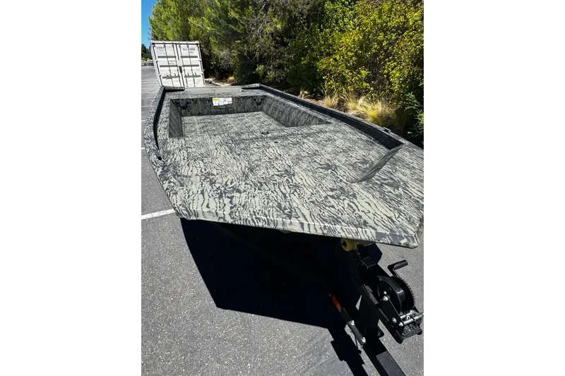 Slide: The Image of 2026 Tracker Grizzly 1860 Utility boat with camouflage design on a trailer. - 24
