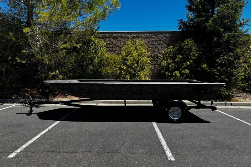 The Image of 2026 Tracker Grizzly 1860 Utility boat on trailer in parking lot. - 0