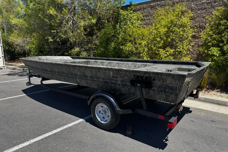 Slide: The Image of 2026 Tracker Grizzly 1860 Utility boat on trailer, parked outdoors. - 3