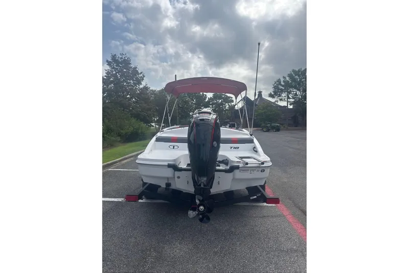 Slide: The Image of 2026 Tahoe T18 boat with outboard motor on a trailer, parked under cloudy skies. - 3