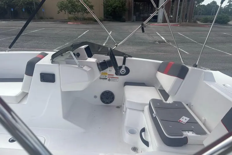 Slide: The Image of 2026 Tahoe T18 boat interior with seating and steering wheel in a parking lot. - 8