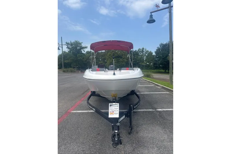 Slide: The Image of 2026 Tahoe T18 boat on trailer in parking lot, under clear sky. - 2